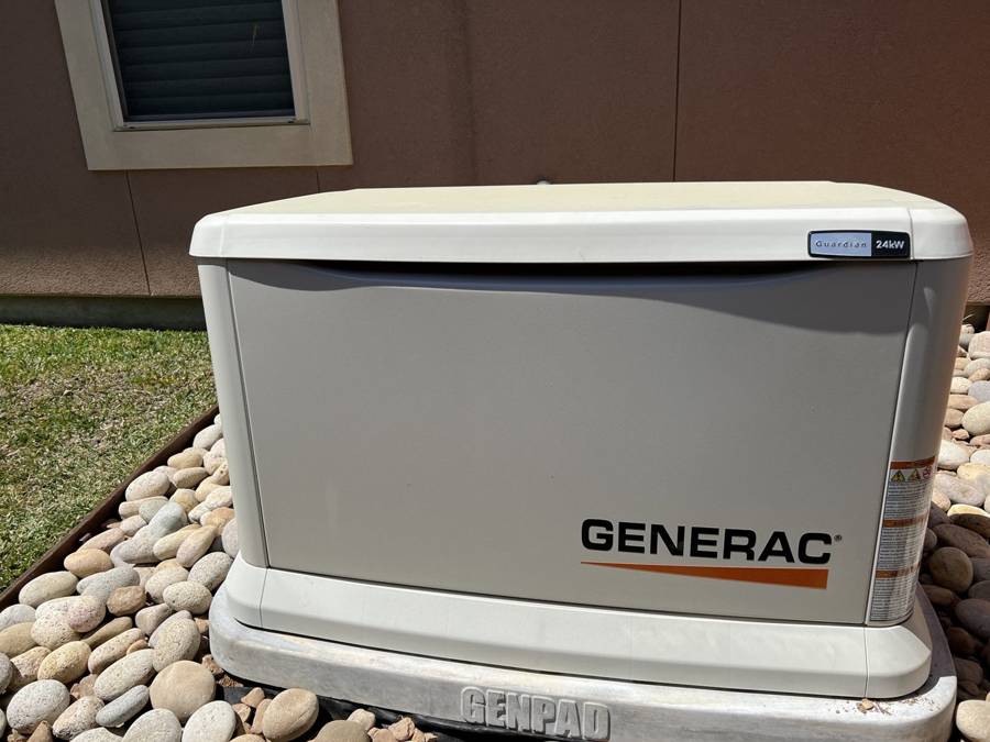 Generac home standby generator installed on a river-rock bed