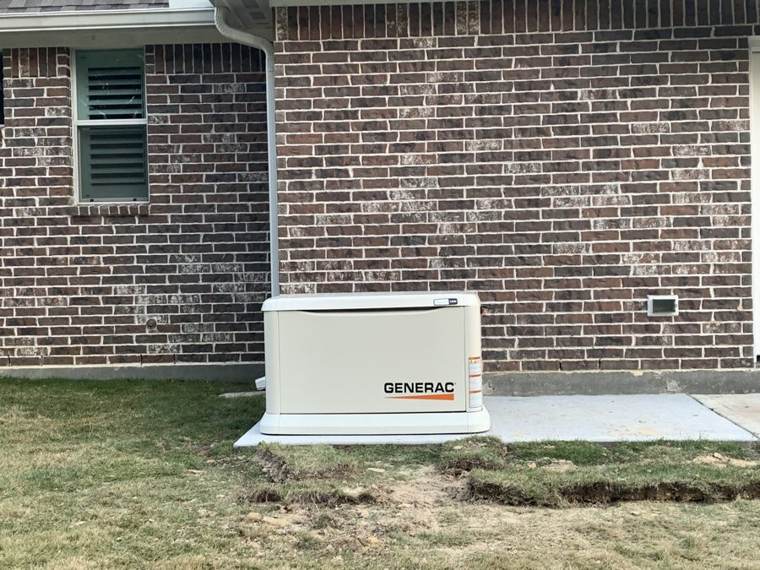 Generac generator installed against a brick home